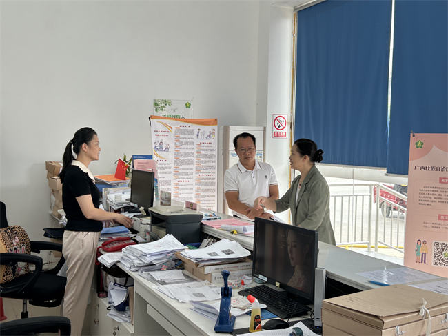 图为在上思县残疾人综合服务大厅与工作人员详细交谈